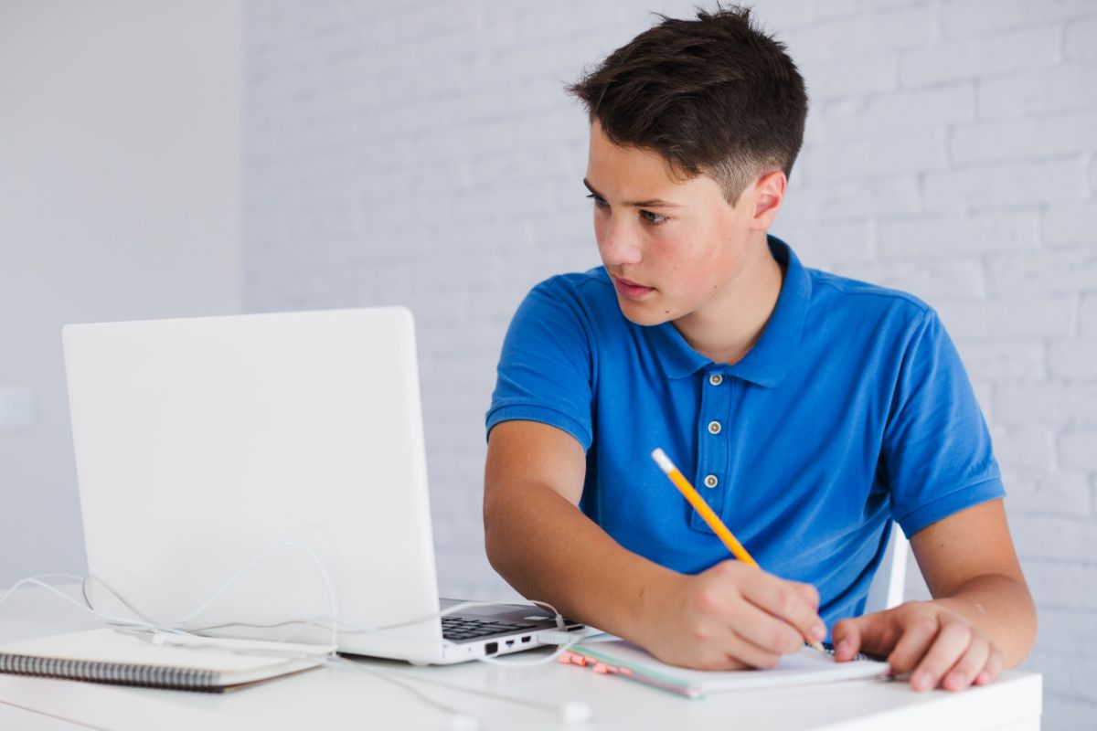 adolescente-haciendo-notas-mirando-portatil (1)